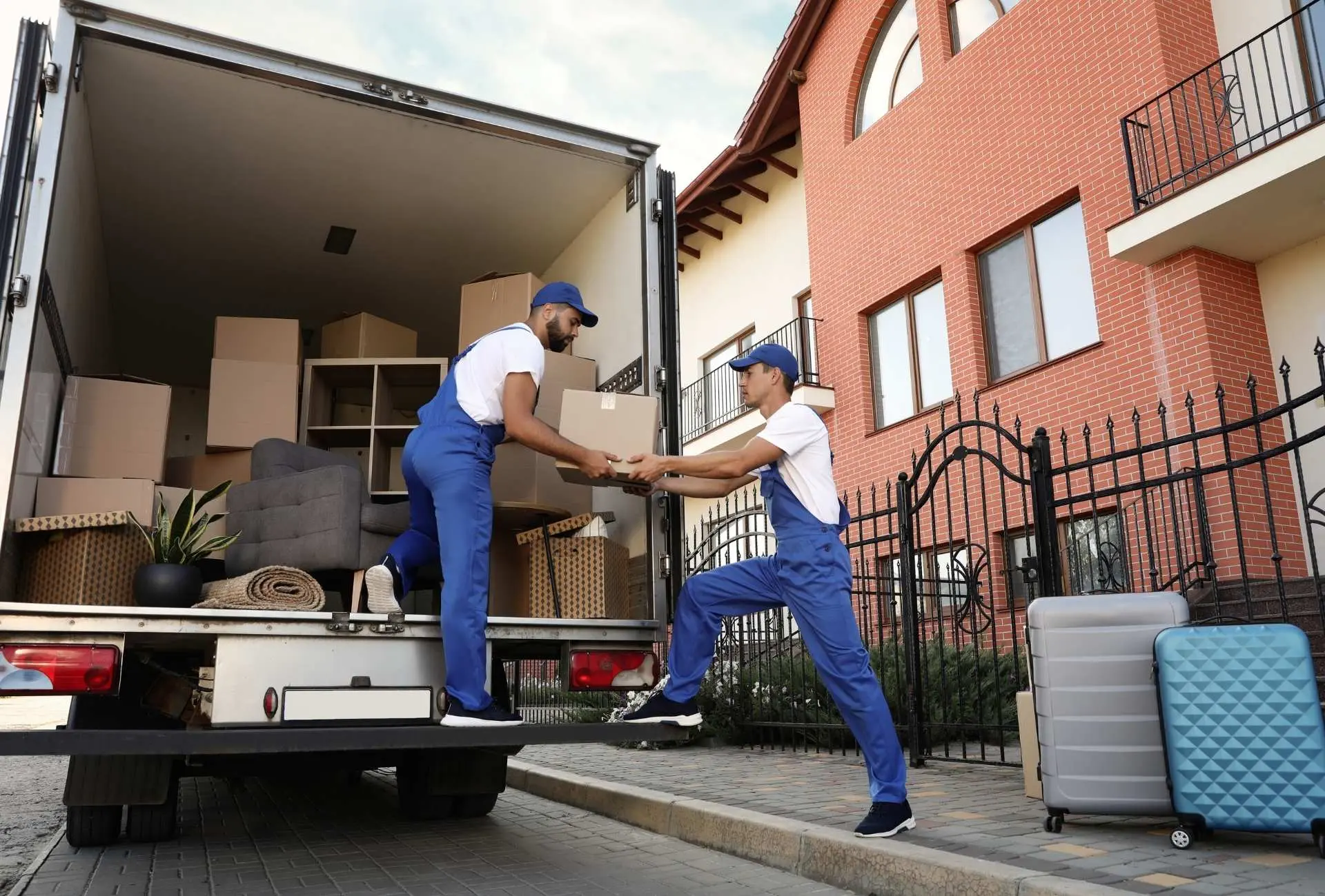 Professional movers and packers carefully loading boxes into a moving truck