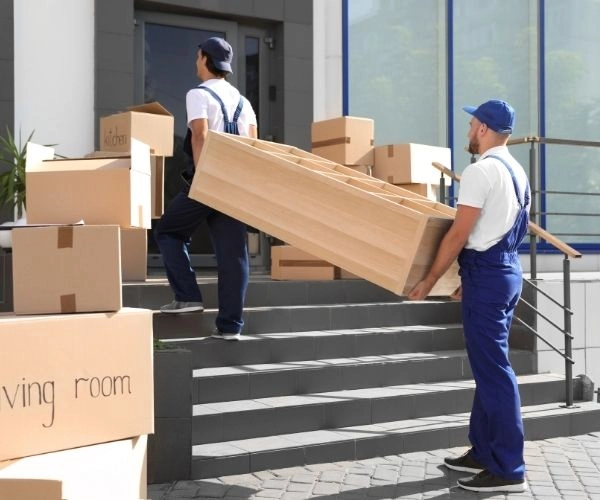 Moving labor specialists carefully lifting boxes into a moving truck
